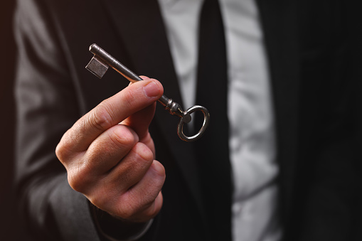 Businessman holding vintage door key, selective focus