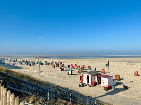 Borkum, Germany - March, 26 - 2022: Main beach with huts and beach chairs.