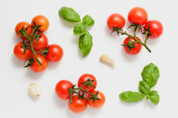 istock Cherry tomatoes on branches with green basil and garlic. 1389831587