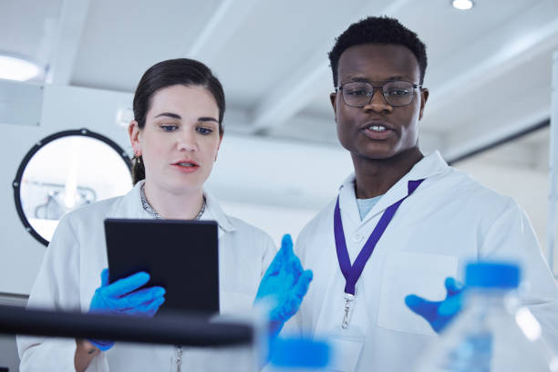 istock Shot of two colleagues working together on a scientific project using a digital tablet 1389831857
