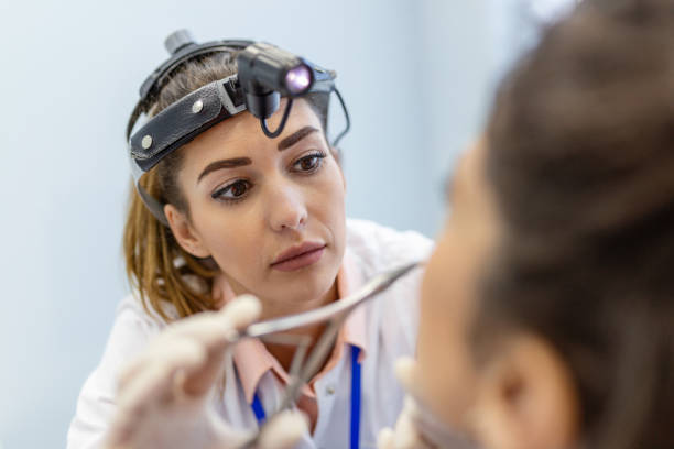 Otolaryngology concept. Positive woman otorhinolaryngologist checking nose with otoscope of his patient at hospital. Nasal congestion, sinusitis, allergy concept. Female patient at modern ENT clinic. concepto de otorrinolaringología. mujer otorrinolaringóloga positiva revisando la nariz con otoscopio de su paciente en el hospital. congestión nasal, sinusitis, concepto de alergia. paciente femenina en la clínica otorrinolaringológica moderna.