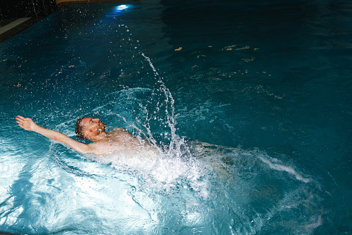 Young man swimming in the indoor swimming pool.