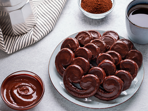 Tasty breakfast with chocolate palmier pastry cookies and black coffee, top view