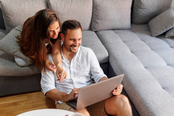 istock Couple chatting online with friends using laptop computer 1389841186