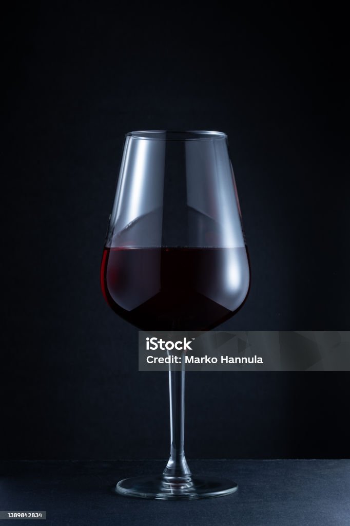 Closeup of a red wine glass against a dark background Helsinki / Finland - APRIL 1, 2022: Closeup of a red wine glass against a dark background Malbec Stock Photo