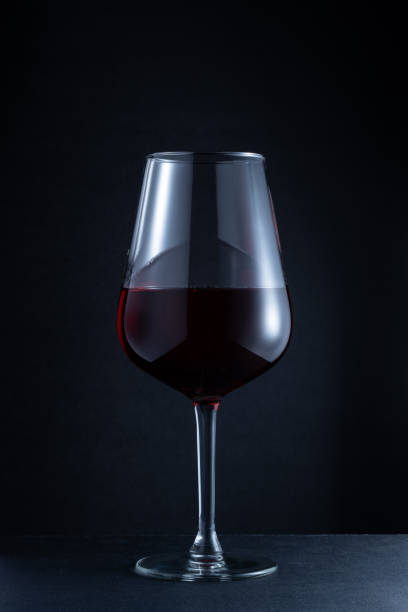 Closeup of a red wine glass against a dark background stock photo