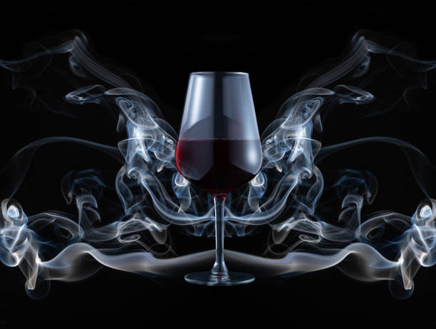 closeup of a red wine glass in front of a smoke installation - pinot noir grape imagens e fotografias de stock