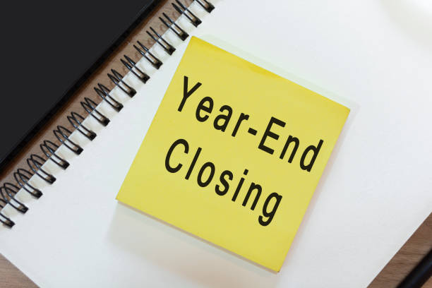 istock Text on yellow note with notepad on wooden desk - Year-end closing 1389843536