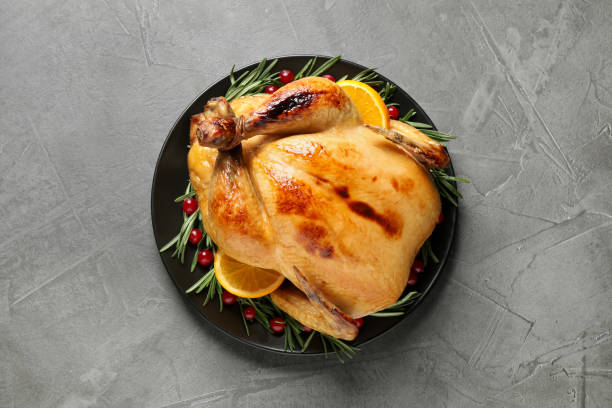 istock Delicious cooked turkey served with rosemary, oranges and cranberries on grey table, top view. Thanksgiving Day celebration 1389843723