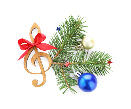Fir tree branch with wooden music note and Christmas ball on white background, top view
