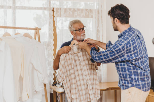 istock Young man help elder senior Choose Good Clothes for holiday outing travel. 1389845320