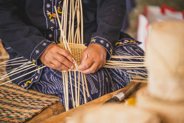 donna asiatica della tribù delle colline che tesse artigianalmente strisce di bambù per cesto o vassoio. - craft product foto e immagini stock