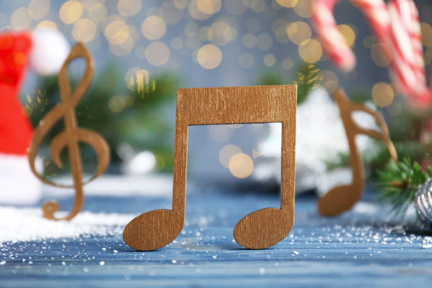 istock Wooden music note on light blue table against blurred Christmas lights 1389845779
