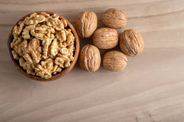 istock Peeled walnuts and whole walnuts on wooden background 1389845822