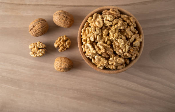 istock Peeled walnuts and whole walnuts on wooden background 1389846652