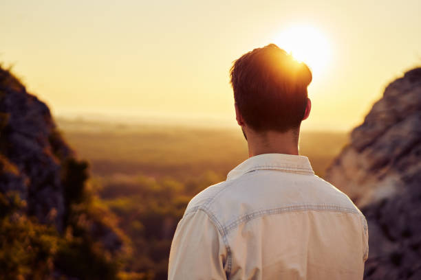 istock Back of a man watching sunset hiking in mountains 1389846734