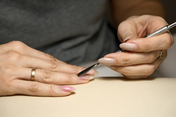 istock Woman doing manicure for herself 1389846794