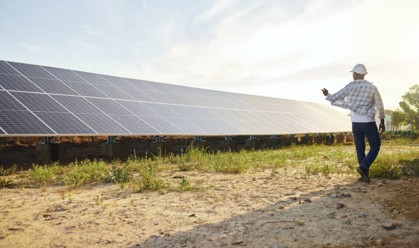 istock Shot of a young man standing next to a solar panel on a farm 1389848450