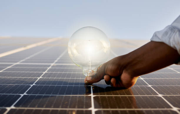 shot of a man holding a light bulb against a solar panel - solar panel solar power station solar energy solar equipment imagens e fotografias de stock