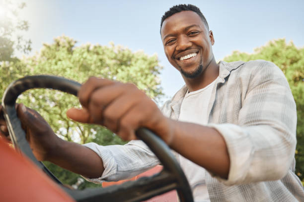 Shot of a young farmer driving a tractor on a farm The perfect environment for growing healthy plant life garden tractor stock pictures, royalty-free photos & images