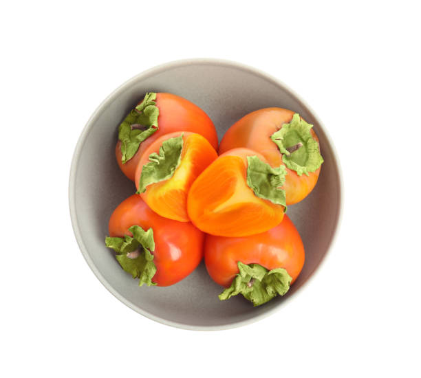 istock Bowl with delicious fresh persimmons isolated on white, top view 1389850150