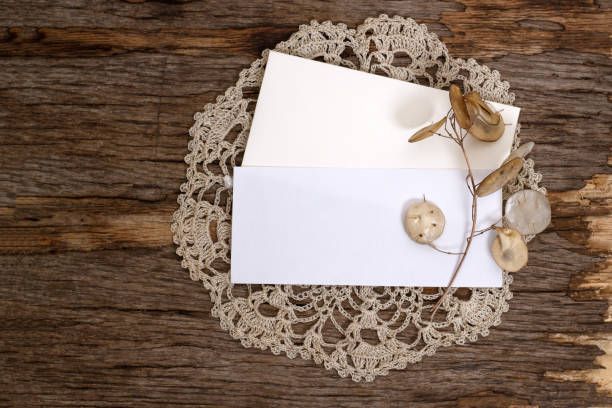 istock Mockup with a blank rectangular sheet of paper and an envelope on a knitted napkin on a wooden background. Template for branding and advertising 1389851920