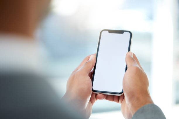 istock Cropped shot of an unrecognizable businessman using his cellphone while standing in the office 1389854455