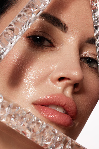 Beautiful woman with laboratory containers with liquid, make-up and hairstyle. Beauty face. The photo was taken in a studio on a white background.