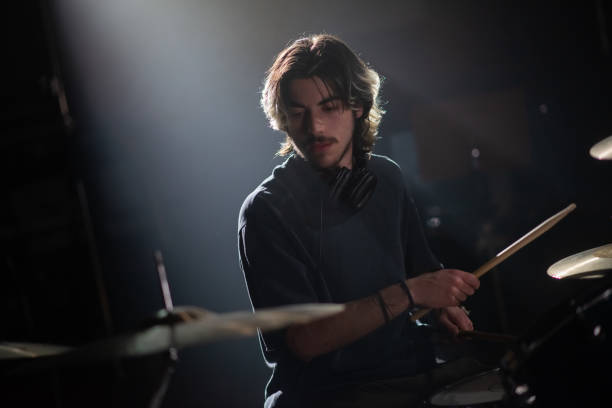 istock Portrait of concentrated young man playing drum set 1389855413