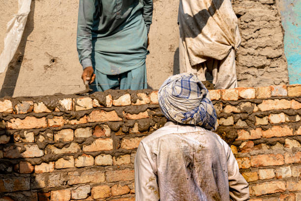 istock Mason and laborer working on a construction site 1389856658