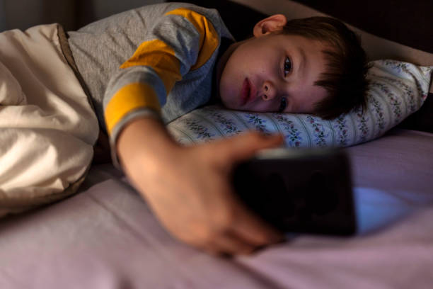 istock Sleeping young woman lying on her bed watching something on her phone. 1389857118