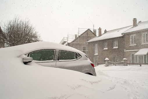 Car buried under snow in a village