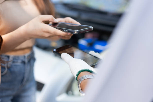 Asian women get contact numbers from Asian male auto mechanics after fixing the car engine problem and QR code scan to pay for fixing vehicle service. Car repair, and maintenance concept. las mujeres asiáticas obtienen números de contacto de mecánicos de automóviles masculinos asiáticos después de solucionar el problema del motor del automóvil y escanear el código qr para pagar el servicio de reparación del vehículo. concepto de r