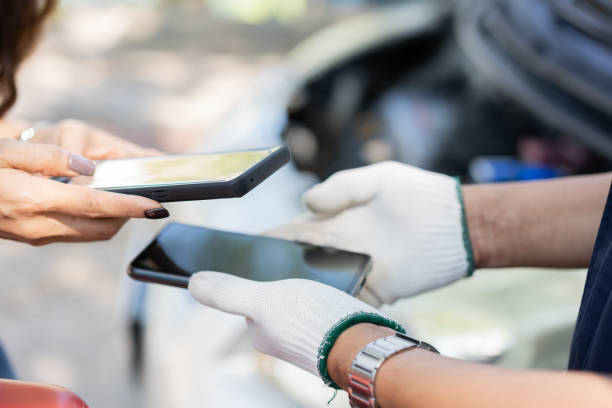 Asian women get contact numbers from Asian male auto mechanics after fixing the car engine problem and QR code scan to pay for fixing vehicle service. Car repair, and maintenance concept. las mujeres asiáticas obtienen números de contacto de mecánicos de automóviles masculinos asiáticos después de solucionar el problema del motor del automóvil y escanear el código qr para pagar el servicio de reparación del vehículo. concepto de r