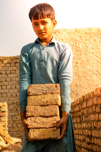 istock Poor children are forced to work construction 1389858187