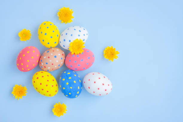 istock Colorful eggs and yellow Chrysanthemum flowers on blue background 1389859480