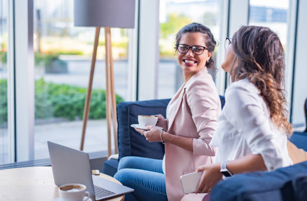 istock Two happy female coworkers drinking coffee 1389859671