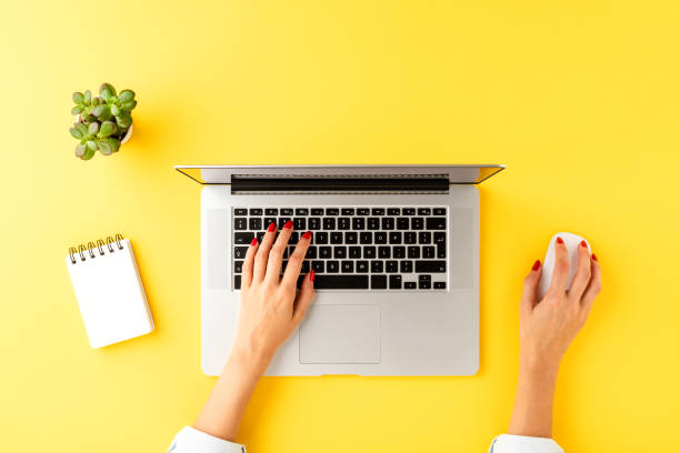 istock Office desktop with woman’s hands working on laptop. Business background with accessories 1389860986