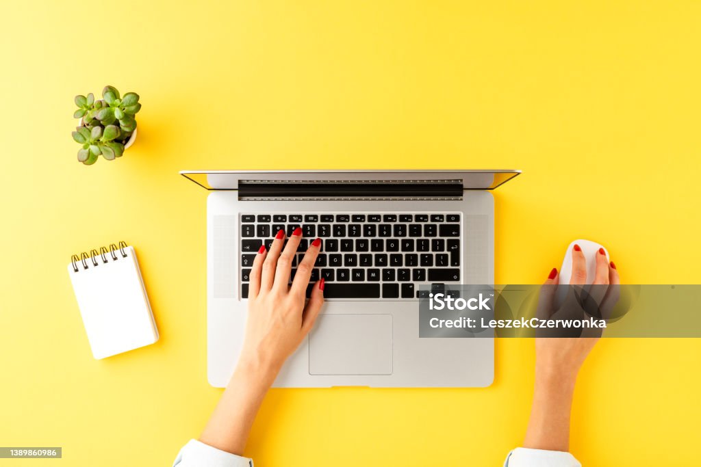 Office desktop with woman’s hands working on laptop. Business background with accessories Laptop Stock Photo