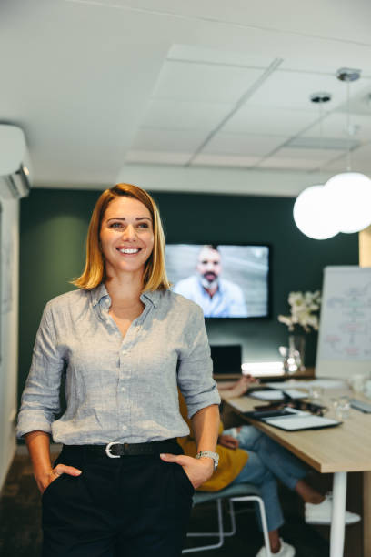 istock Cheerful business manager standing in a boardroom 1389862031