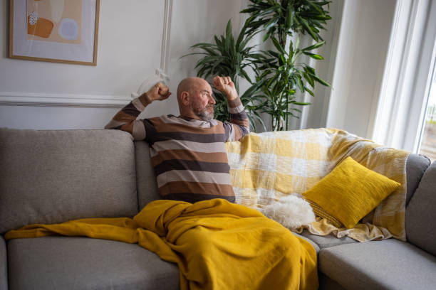 istock Caucasian senior man relaxing on the sofa with Maltese dog 1389862454