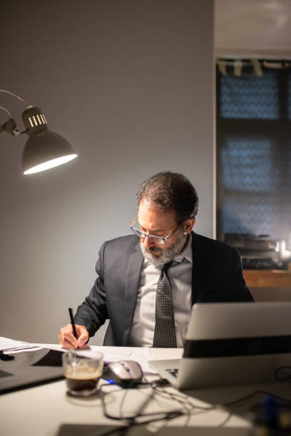 istock Focused bearded man working late at night 1389862796