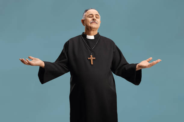 istock Mature priest with closed eyes spreading arms 1389868035