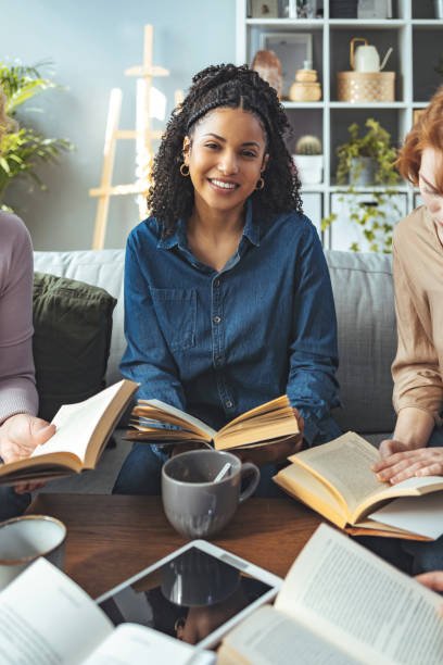 istock Young female reading a book at the library 1389869888