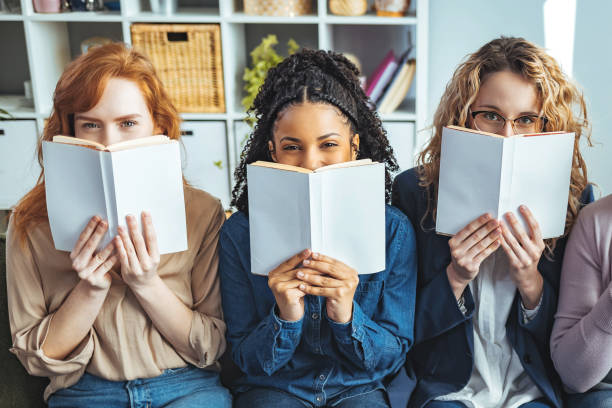 istock College students hiding behind a books and looking at camera 1389869909