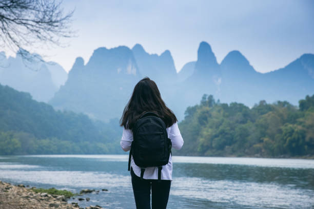 Woman tourist enjoyment in nature Woman tourist walking by Li river in Guilin，China guilin hills stock pictures, royalty-free photos & images