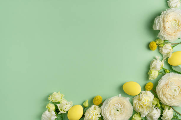 istock Coloured yellow eggs and various white flowers on light green background. Easter layout in pastel colours. Spring holiday composition. Flowers and chicken eggs mockup. Copy space, flat lay, top view 1389872789