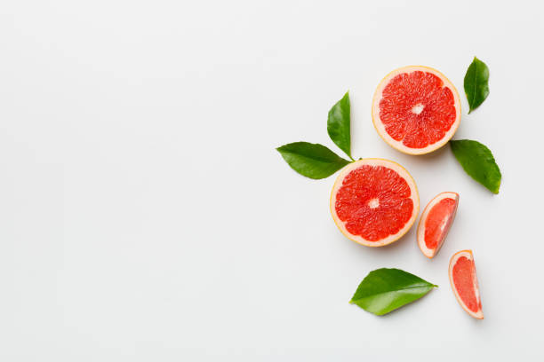 istock fresh Fruit grapefruit with Juicy grapefruit slices on colored background. Top view. Copy Space. creative summer concept. Half of citrus in minimal flat lay with copy space 1389874523