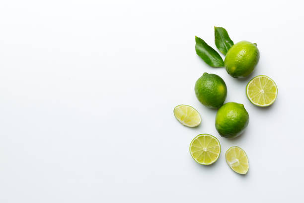 istock Lime fruits with green leaf and cut in half slice isolated on white background. Top view. Flat lay with copy space 1389874540