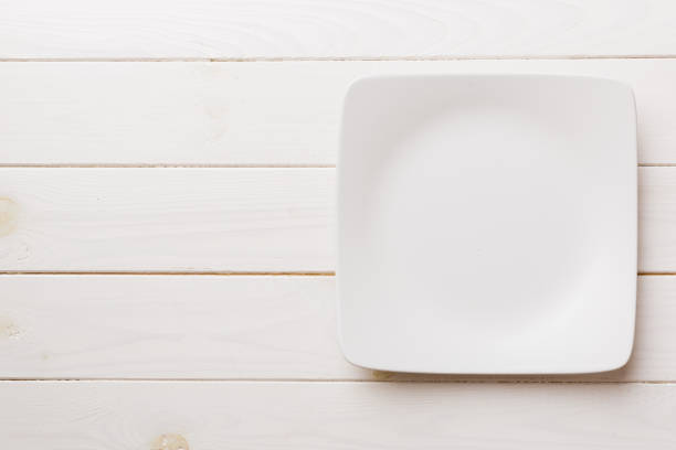 istock Top view of empty square plate on wooden background. Empty space for your design 1389874566